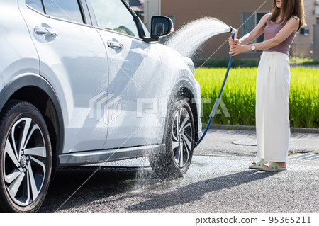 A woman washing a car car wash A woman washing a car car wash 95365211