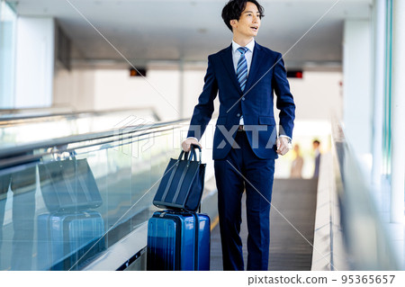 Businessman walking through airport aisle Businessman walking through airport aisle 95365657
