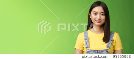 Waist-up friendly cheerful teenage asian college girl stand green background, smiling lovely, look tender amused, have relaxing casual conversation, packing things summer journey 95365998