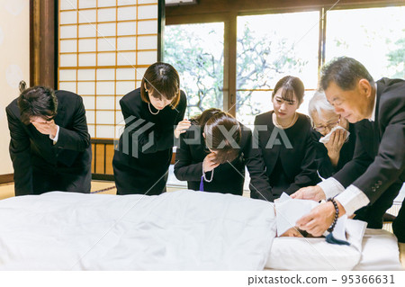 A bereaved family who mourns the deceased around a futon at a funeral / wake (crying) A bereaved family who mourns the deceased around a futon at a funeral / wake (crying) 95366631