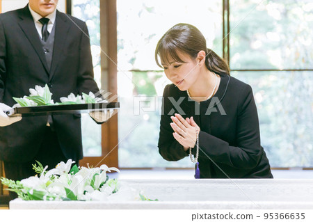 A Japanese woman who performs a flower vase ceremony at a funeral coffin (smile, gassho) A Japanese woman who performs a flower vase ceremony at a funeral coffin (smile, gassho) 95366635