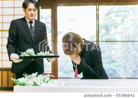 在葬禮上將鮮花放入棺材的日本婦女（合掌） 95366642