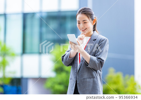 拿著智能手機的微笑的女商人 95366934