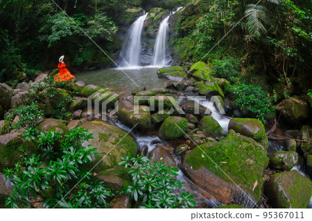 Beautiful woman in red dress in front of the Sapan Waterfall, Khun Nan National Park, Boklua District, Nan Province, Thailand. Beautiful woman in red dress in front of the Sapan Waterfall, Khun Nan National Park, Boklua District, Nan Province, Thailand. 95367011