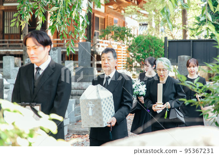 Bereaved family attending the burial ceremony at the funeral Bereaved family attending the burial ceremony at the funeral 95367231