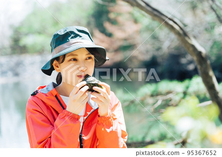 A woman eating rice balls in nature 95367652