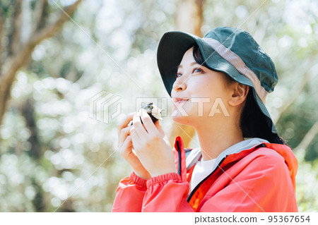 一個在大自然中吃飯糰的女人 95367654