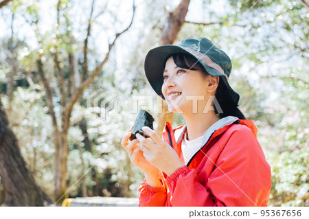 一個在大自然中吃飯糰的女人 95367656