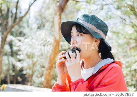 A woman eating rice balls in nature 95367657