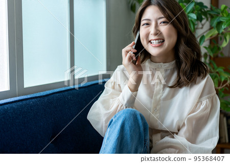 Young woman calling on the sofa Young woman calling on the sofa 95368407