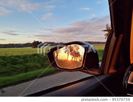 Sunrise light reflection in rear car mirror Sunrise light reflection in rear car mirror 95370739