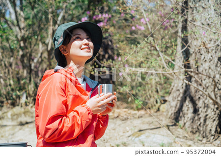 Woman drinking coffee in nature 95372004