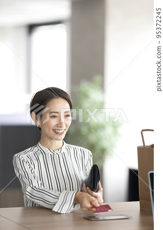 A woman shopping with a credit card 95372245