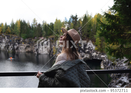 portrait of a beautiful young woman with freckles in a hat on the background of a lake surrounded by trees portrait of a beautiful young woman with freckles in a hat on the background of a lake surrounded by trees 95372711