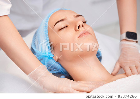 woman receiving facial massage at spa salon woman receiving facial massage at spa salon 95374260