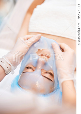 beautician removing mask from face of beautiful woman beautician removing mask from face of beautiful woman 95374273