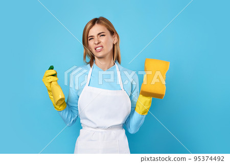 woman in gloves and cleaner apron with sponge and detergent sprayer 95374492