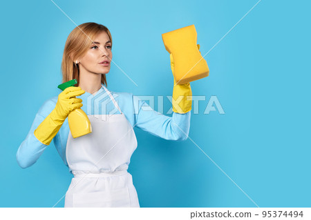 woman in gloves and cleaner apron with sponge and detergent sprayer 95374494