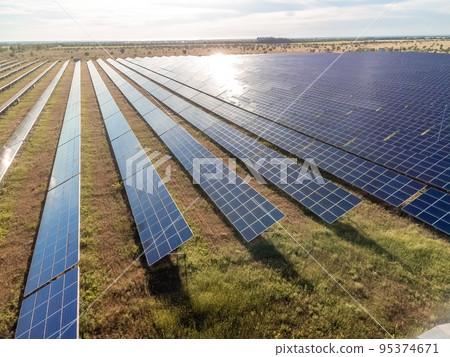 Aerial top view of a solar panels power plant. Photovoltaic solar panels at sunrise and sunset in countryside from above. Modern technology, climate care, earth saving, renewable energy concept. 95374671
