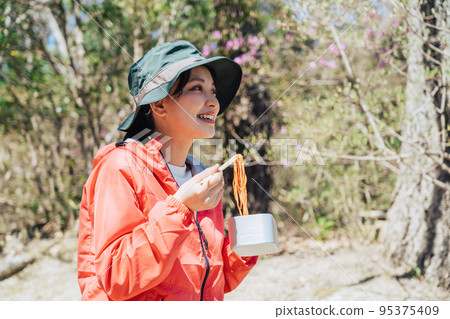 A woman eating food using Mestin for mountaineering 95375409