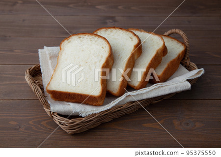Thick-sliced mountain-shaped bread on a wooden table Thick-sliced mountain-shaped bread on a wooden table 95375550