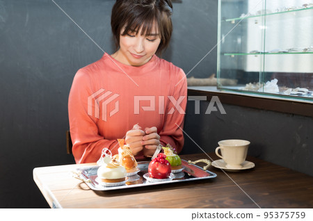 一個在咖啡館挑選蛋糕的女人 一個在咖啡館挑選蛋糕的女人 95375759
