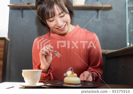 在咖啡館吃蛋糕的女人 在咖啡館吃蛋糕的女人 95375910