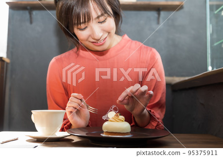 在咖啡館吃蛋糕的女人 在咖啡館吃蛋糕的女人 95375911