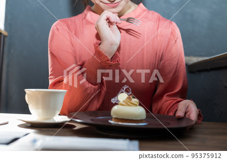 在咖啡館吃蛋糕的女人 在咖啡館吃蛋糕的女人 95375912
