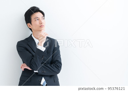 A young businessman who thinks A young businessman who thinks 95376121