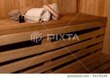 Traditional old Russian bathhouse SPA Concept. Interior details Finnish sauna steam room with traditional sauna accessories set basin towel aroma oil scoop felt. Relax country village bath concept 95376199