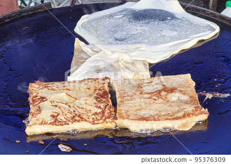 Murtabak on cooking pan at street market during muslim iftar season Murtabak on cooking pan at street market during muslim iftar season 95376309