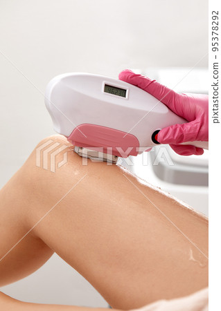 Laser depilation or photoepilator process on a woman leg. Laser depilation or photoepilator process on a woman leg. 95378292