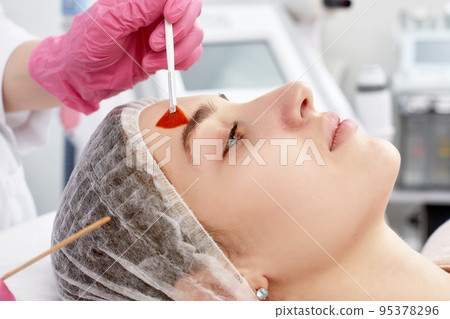 procedure of photoepilation in the beauty salon. Young Woman Receiving Epilation Laser Treatment On Face At Beauty Center Close Up procedure of photoepilation in the beauty salon. Young Woman Receiving Epilation Laser Treatment On Face At Beauty Center Close Up 95378296