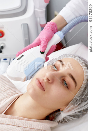 procedure of photoepilation in the beauty salon. Young Woman Receiving Epilation Laser Treatment On Face At Beauty Center Close Up procedure of photoepilation in the beauty salon. Young Woman Receiving Epilation Laser Treatment On Face At Beauty Center Close Up 95378299