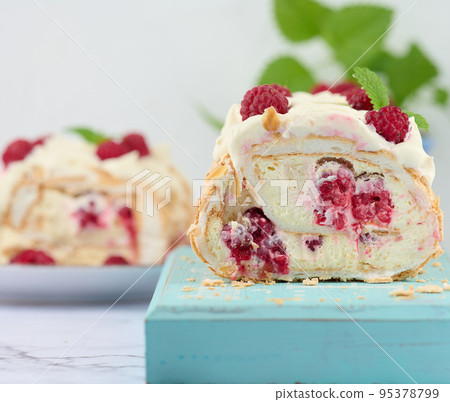 Baked meringue roll with cream and fresh red raspberry, white background. Baked meringue roll with cream and fresh red raspberry, white background. 95378799