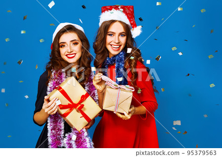 nice portrait of two happy young women in santa claus hat with gift .Christmas concept. 95379563