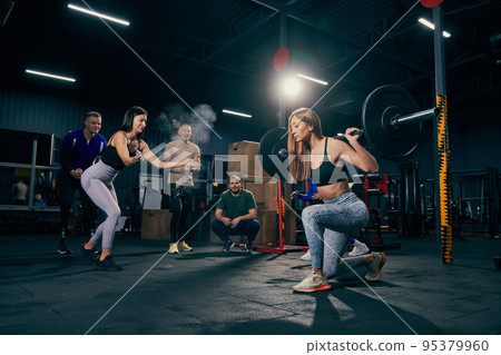 Group training. Sportive youth, muscled men and women in sports uniform workout at sport gym, indoors. Sport, active lifestyle, health, youth concept Group training. Sportive youth, muscled men and women in sports uniform workout at sport gym, indoors. Sport, active lifestyle, health, youth concept 95379960