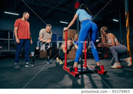Young, sportive and motivated. Group of young friends doing sports, training at gym indoors. Sport achievements, challenges, hobbies, leisure activities 95379963