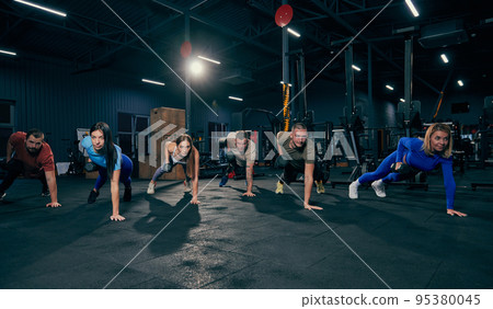 Group training. Sportive youth, muscled men and women in sports uniform workout at sport gym, indoors. Sport, active lifestyle, health, youth concept Group training. Sportive youth, muscled men and women in sports uniform workout at sport gym, indoors. Sport, active lifestyle, health, youth concept 95380045