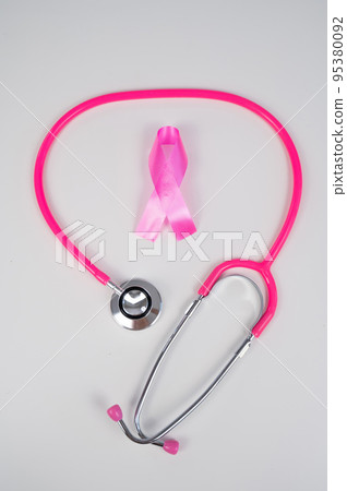 Pink ribbon and stethoscope on a white background. The concept of the fight against breast cancer.  95380092