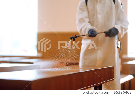 Disinfectant sprayer in the hand of man in protective hazmat suit. Disinfecting schools during coronavirus. 95380462
