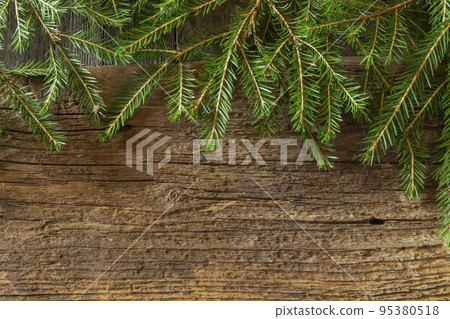 Green branches of spruce on an old wooden board Green branches of spruce on an old wooden board 95380518