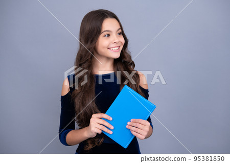 Happy smiling teenager school girl. Schoolchild, teenage student girl hold book on gray isolated studio background. School and education concept. Back to school. 95381850
