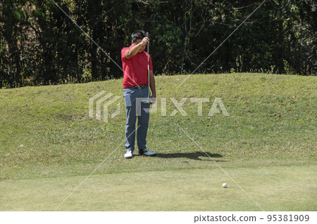 Golfer are playing game golf and hitting go on green grass mountain background. Asia male player game shot in summer. Golfer are playing game golf and hitting go on green grass mountain background. Asia male player game shot in summer. 95381909