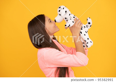 happy teen girl in home terry bathrobe with toy, love 95382991