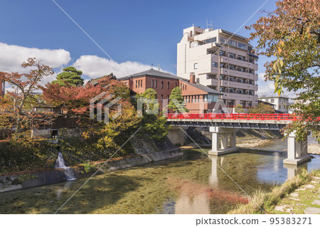 Takayama Japan, autumn landscape foliage at red Nakabashi bridge and Miyakawa river 95383271