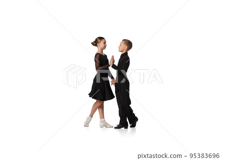 Two kids, school age girl and boy in black stage costumes dancing ballroom dance isolated on white background. Art, sport dance, music, studying 95383696