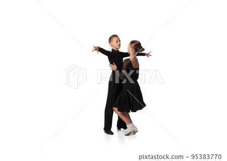Two kids, school age girl and boy in black stage costumes dancing ballroom dance isolated on white background. Art, sport dance, music, studying 95383770