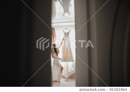 Beautiful bride wearing fashion wedding dress with feathers with luxury delight make-up and hairstyle, studio indoor photo shoot Beautiful bride wearing fashion wedding dress with feathers with luxury delight make-up and hairstyle, studio indoor photo shoot 95383964